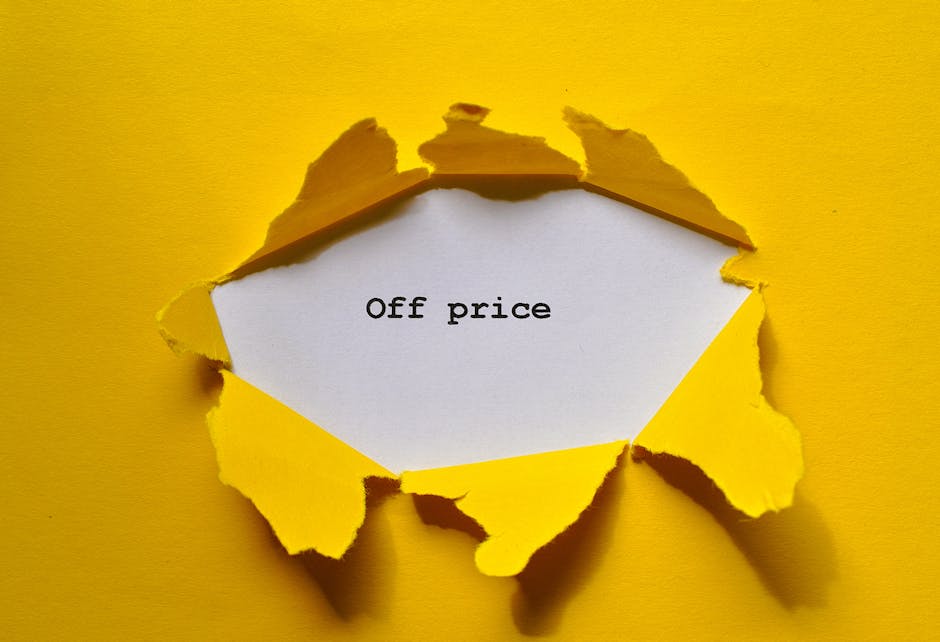 A torn yellow paper background revealing a white note inside that reads 'Off price' in black typewriter-style font. The torn edges of the paper create a rough, jagged border around the note, set against a solid yellow surface which enhances the visual focus on the message. The lighting is even, highlighting the texture of the torn paper and the clarity of the text, embodying a theme of highlighting discounts or reduced prices, relevant for domestic or commercial surface cleaning promotions. The overall composition conveys an emphasis on savings or special offers, suitable for content about affordable cleaning services offered by Colliers Wood Carpet Cleaning.